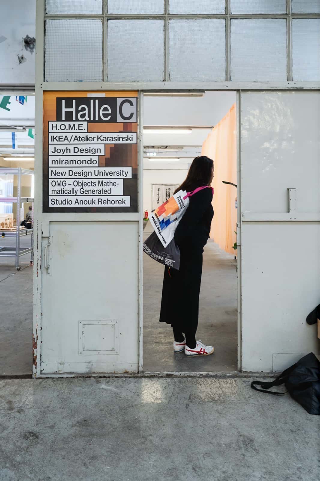 Image of a person standing in the doorway towards Hall C, with a sign giving information on the contents.