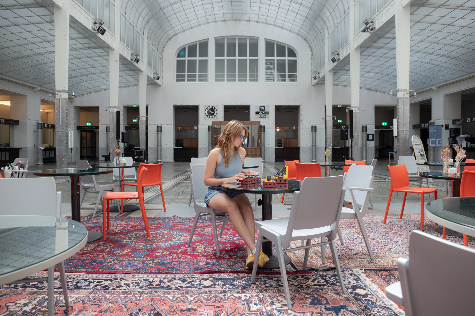 a person sitting in a large beautiful building writing on a device