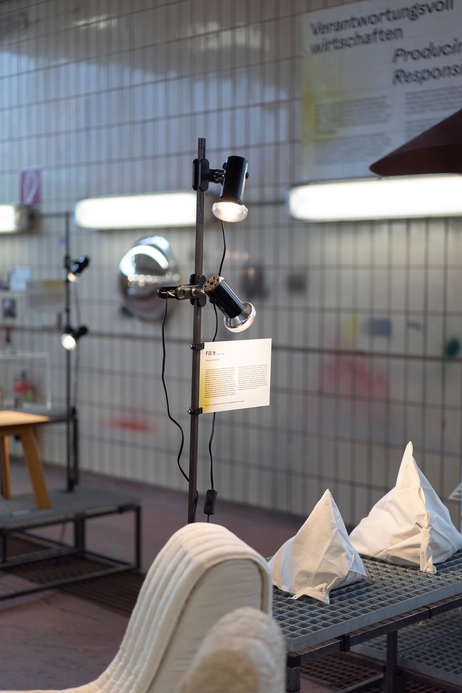 Industrial-style exhibition room illuminated by lamps.