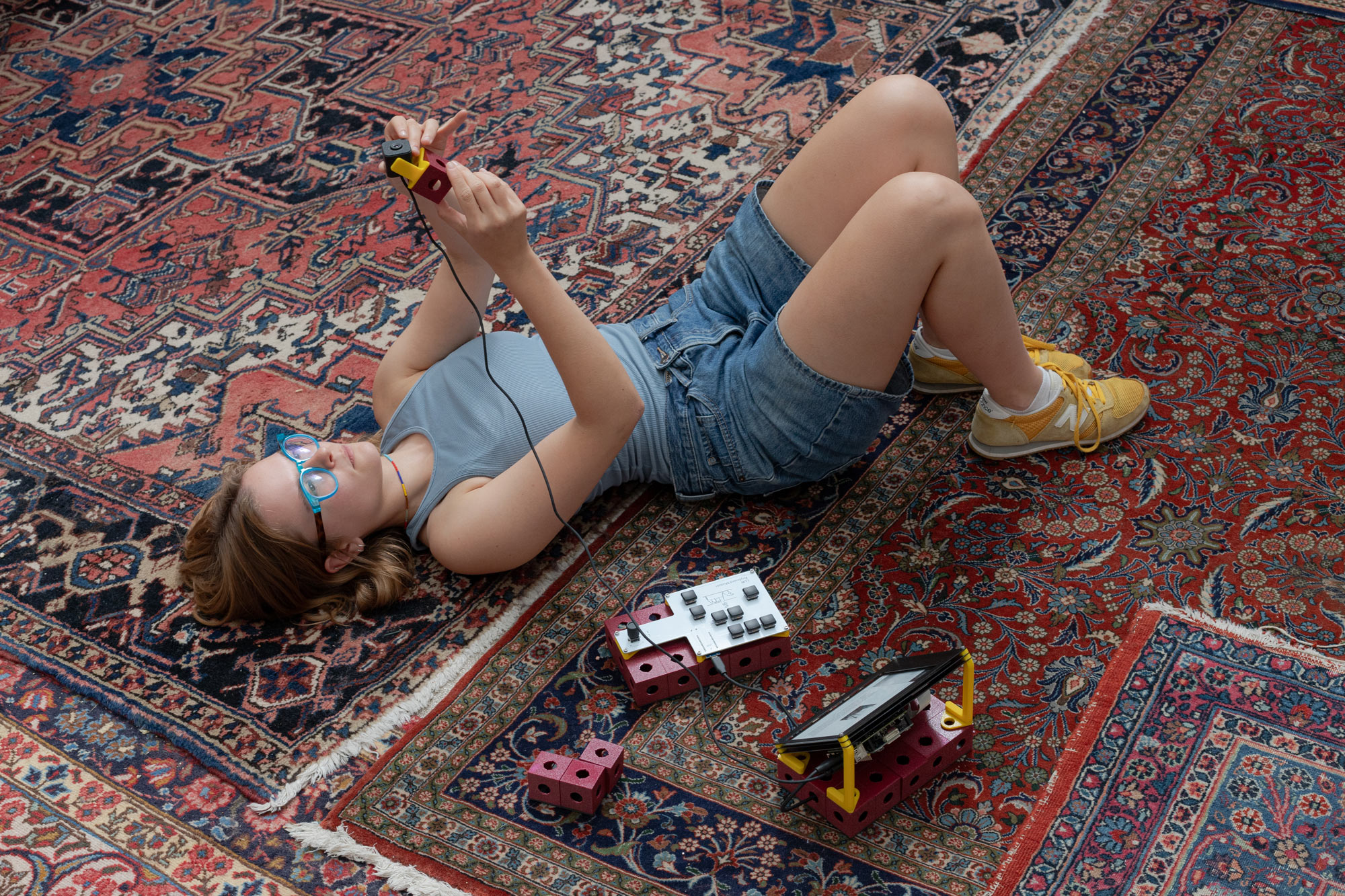 A person is lying on the floor, holding the Large Language Writer's camera up in the air. 