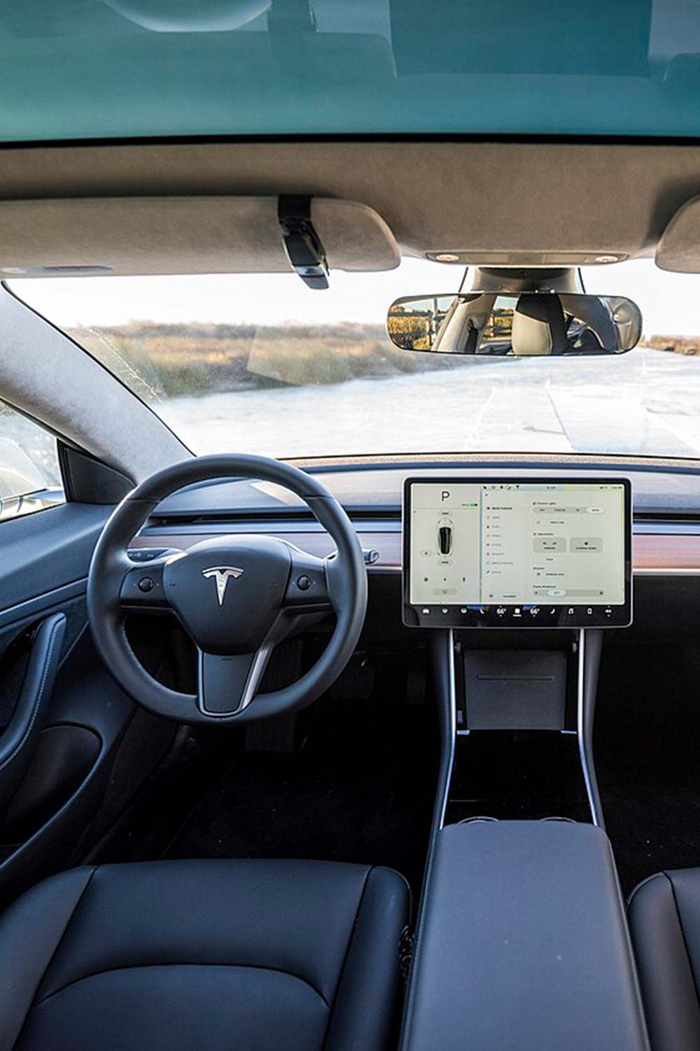 Image of a modern car interior showing only a screen and a steering wheel